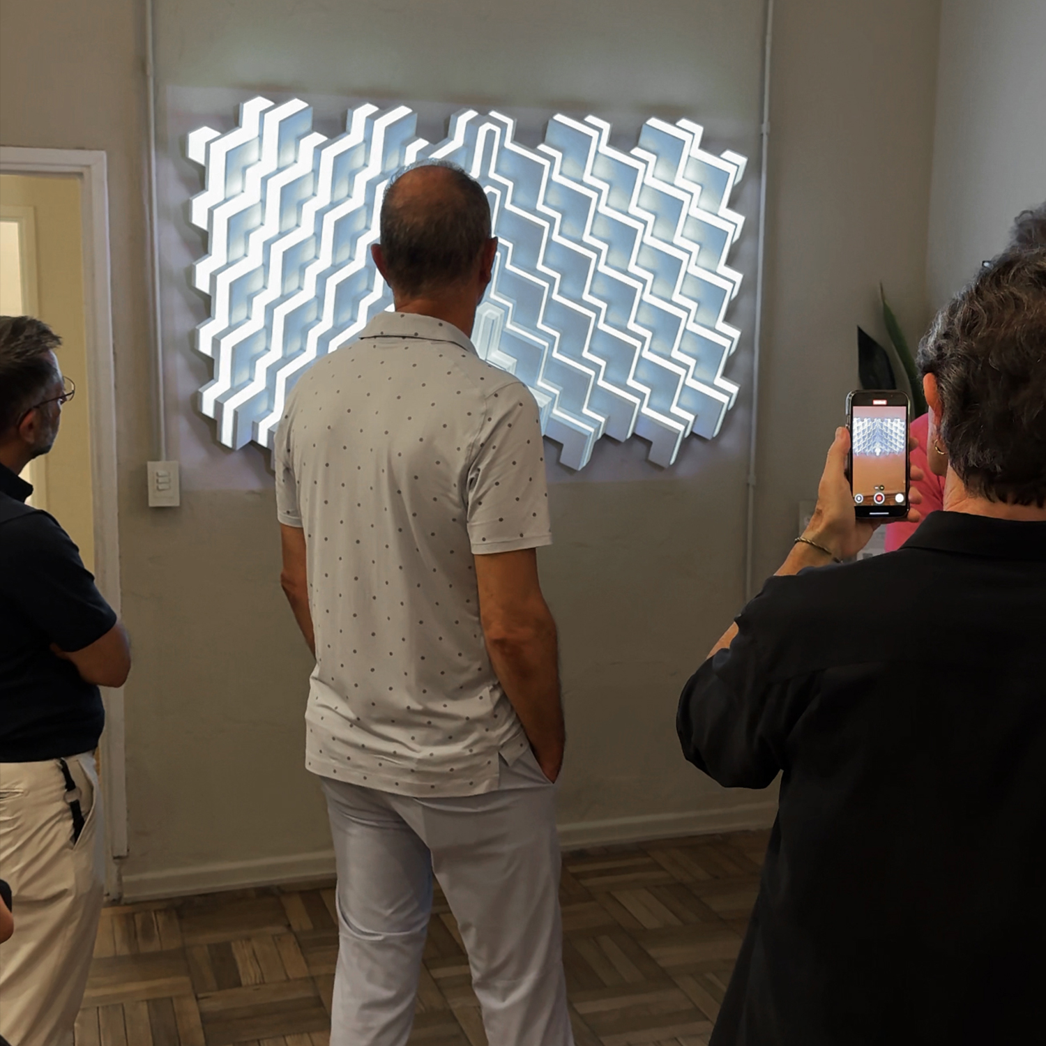 Visitante fotografiando Trinity en UGallery, patrón blanco