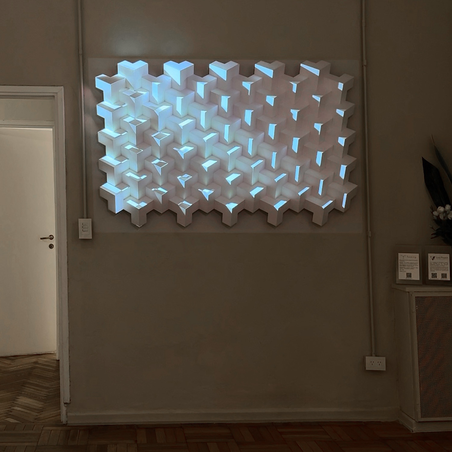 Trinity en UGallery, sala vacía con patrón blanco iluminado