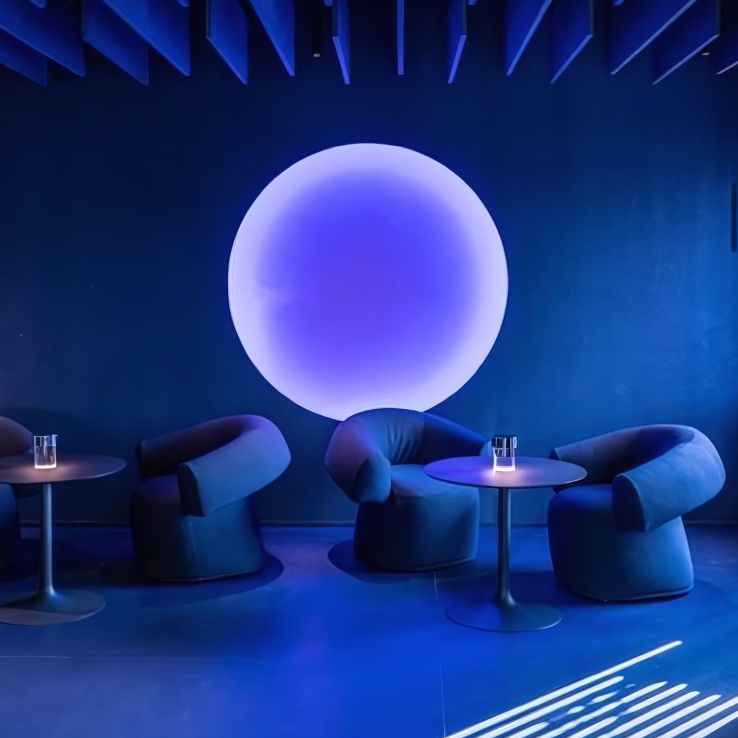 Referencia: círculo de luz violeta detrás de sillones azules