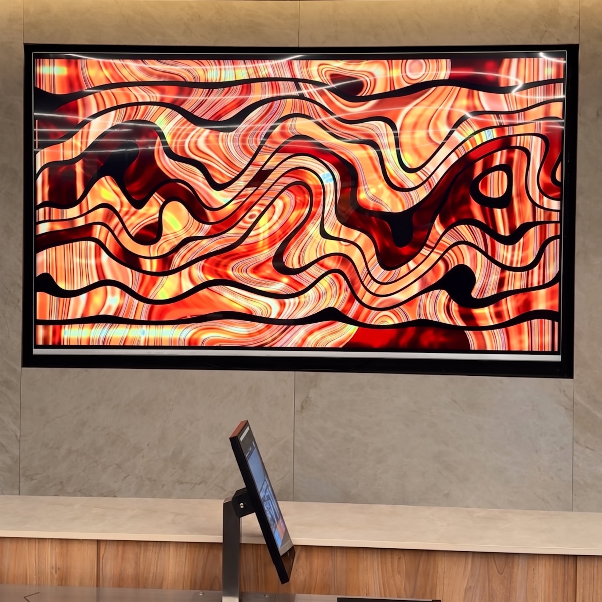 Pantalla LED con visual abstracto de ondas rojas y naranjas en hall de Iconnect
